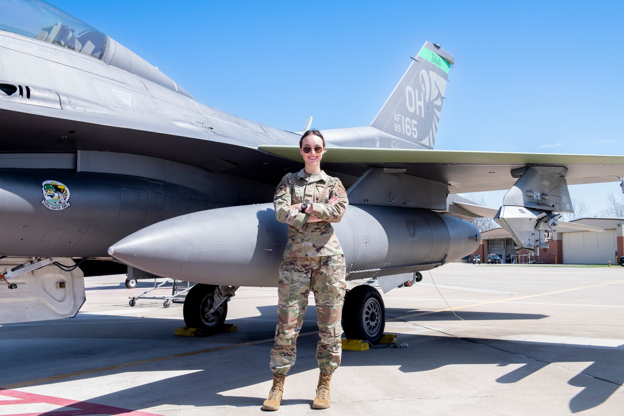 Woman poses in front of F-16.