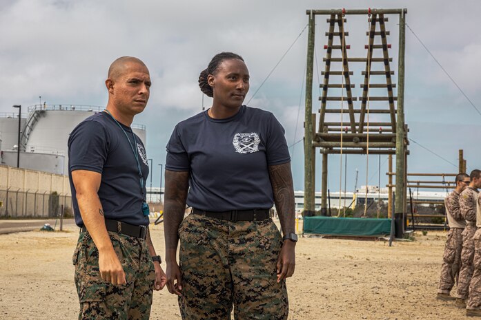 U.S. Marine Corps SSgt Rogelio Alvarez, left, and SSgt JazJuan Wallace-Sipp, right, both chief drill instructors with Mike Company, 3rd Recruit Training Battalion, observe recruits conduct the confidence course at Marine Corps Recruit Depot San Diego, California, June 3, 2024. The confidence course challenges recruits physically, mentally, and spiritually through obstacles that require trust in their strength, balance, and determination. (U.S. Marine Corps photo by Lance Cpl. Jacob B. Hutchinson)