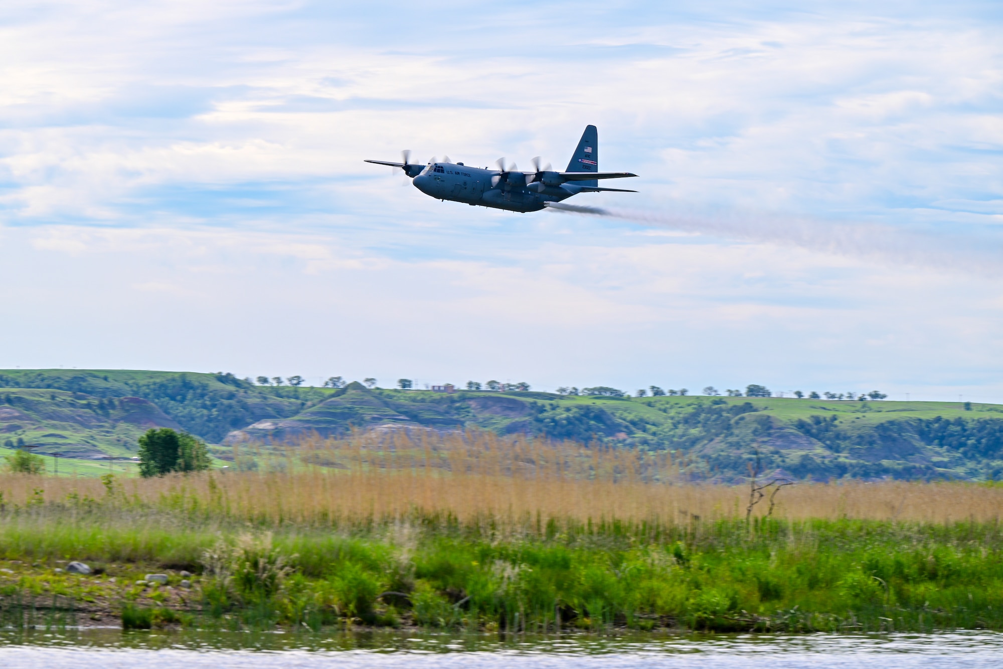 A 910th Airlift Wing aerial spray-modified C-130H Hercules aircraft disperses mosquito control product, June 3, 2024, over the flood banks of the Missouri River south of Williston, North Dakota.