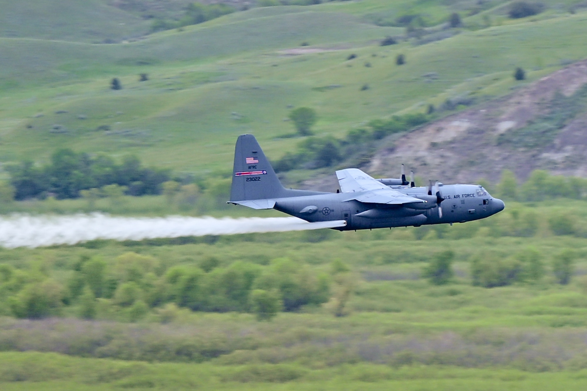 A 910th Airlift Wing aerial spray-modified C-130H Hercules aircraft disperses mosquito control product, June 2, 2024, over the flood banks of the Missouri River south of Williston, North Dakota.