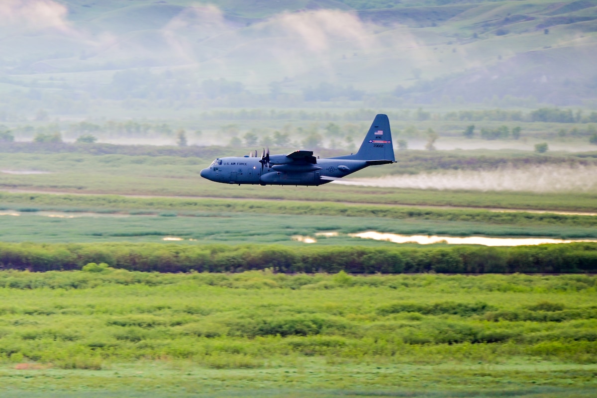 A 910th Airlift Wing aerial spray-modified C-130H Hercules aircraft disperses mosquito control product, June 3, 2024, over the flood banks of the Missouri River south of Williston, North Dakota.