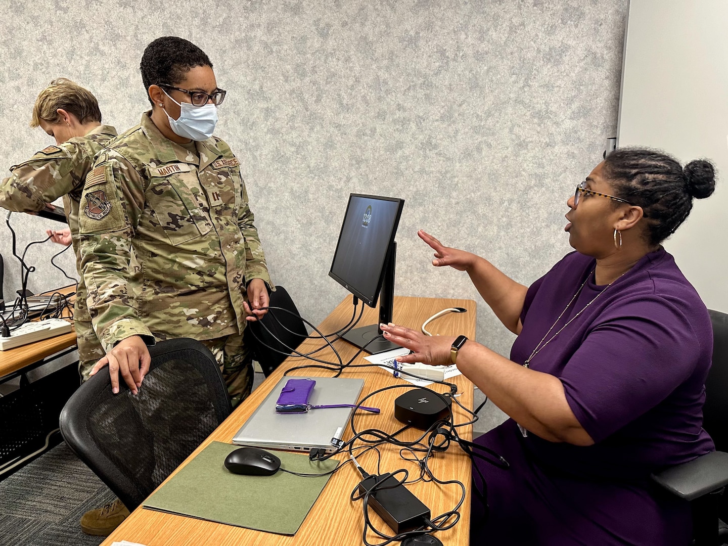 Dr. Ashley Jackson, USMEPCOM Western Sector medical officer (R) guides Air Force Capt. Tanika Martin, physician assistant, through equipment setup during Prescreen Support Coordination Center (PSCC) training. The PSCC allows providers to review military applicant medical prescreens virtually, helping to decrease the amount of time an applicant spends in their MEPS and shortening contact-to-contract time.