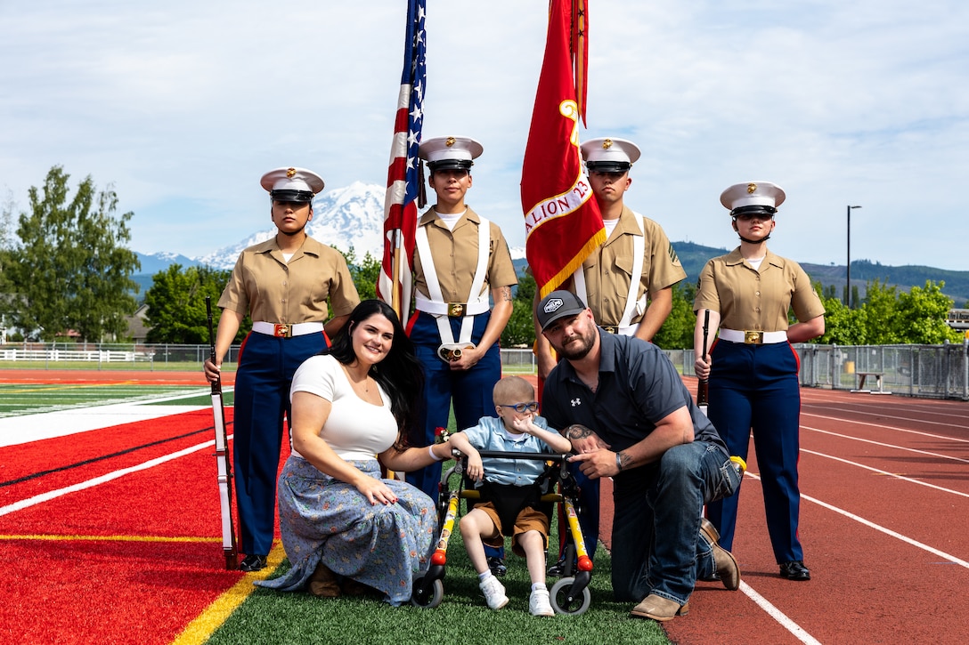 Arlan Russell and his parents pose for a photograph with a Marine Corps color guard at the conclusion of his Honorary Marine ceremony at Orting Middle School in Orting, Wash., June 8, 2024. The title of Honorary Marine is an honor bestowed by the Commandant of the Marine Corps to civilians who have made extraordinary contributions to the Marine Corps. The program began in 1992 and is intended to strengthen the bond between the American people and the Marine Corps. Notable Honorary Marines include Chuck Norris, Gary Sinise, and Joe Rosenthal. Russell is the 109th person to earn the title of Honorary Marine.