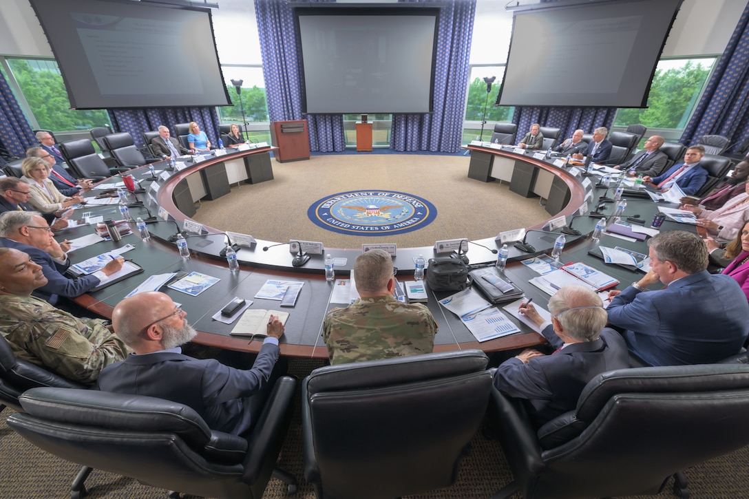 A group of men and women in business attire sit at a round table