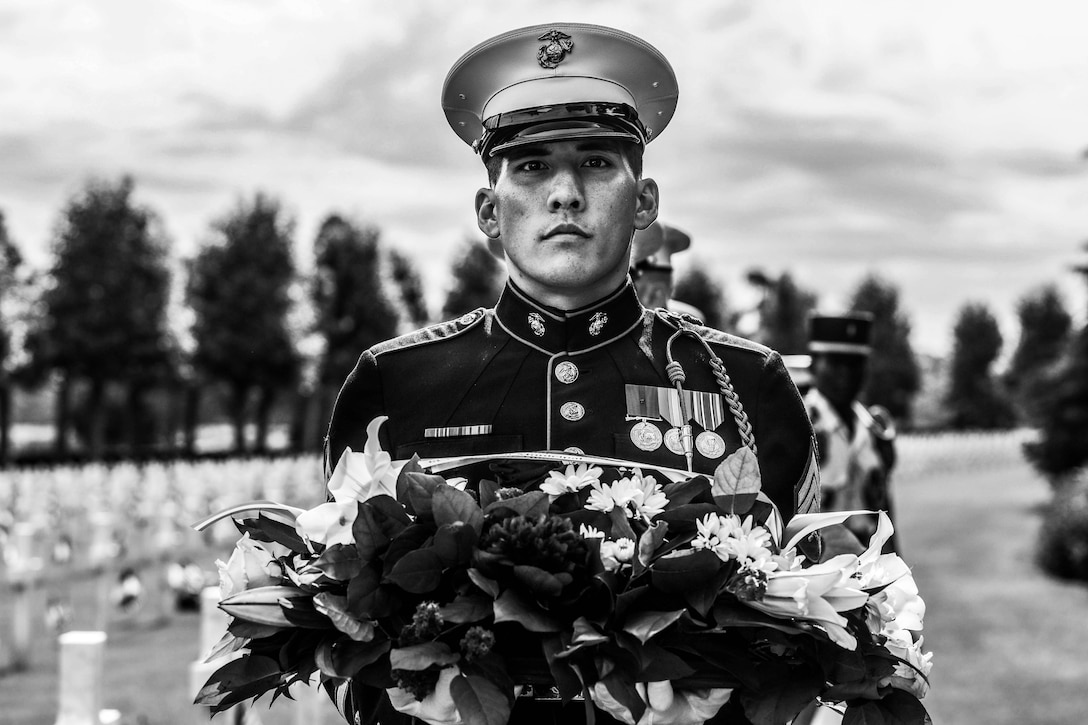U.S. Marine Corps Sgt. Ryan Leblanc, a squad leader with 1st Battalion, 6th Marine Regiment, 2d Marine Division, holds a wreath during a ceremony at the Aisne-Marne American Cemetery, Belleau, France, May 26, 2024. The memorial ceremony was held in commemoration of the 106th anniversary of the battle of Belleau Wood, conducted to honor the legacy of service members who gave their lives in defense of the United States and European allies. (U.S. Marine Corps photo illustration by Sgt. Alexa M. Hernandez)