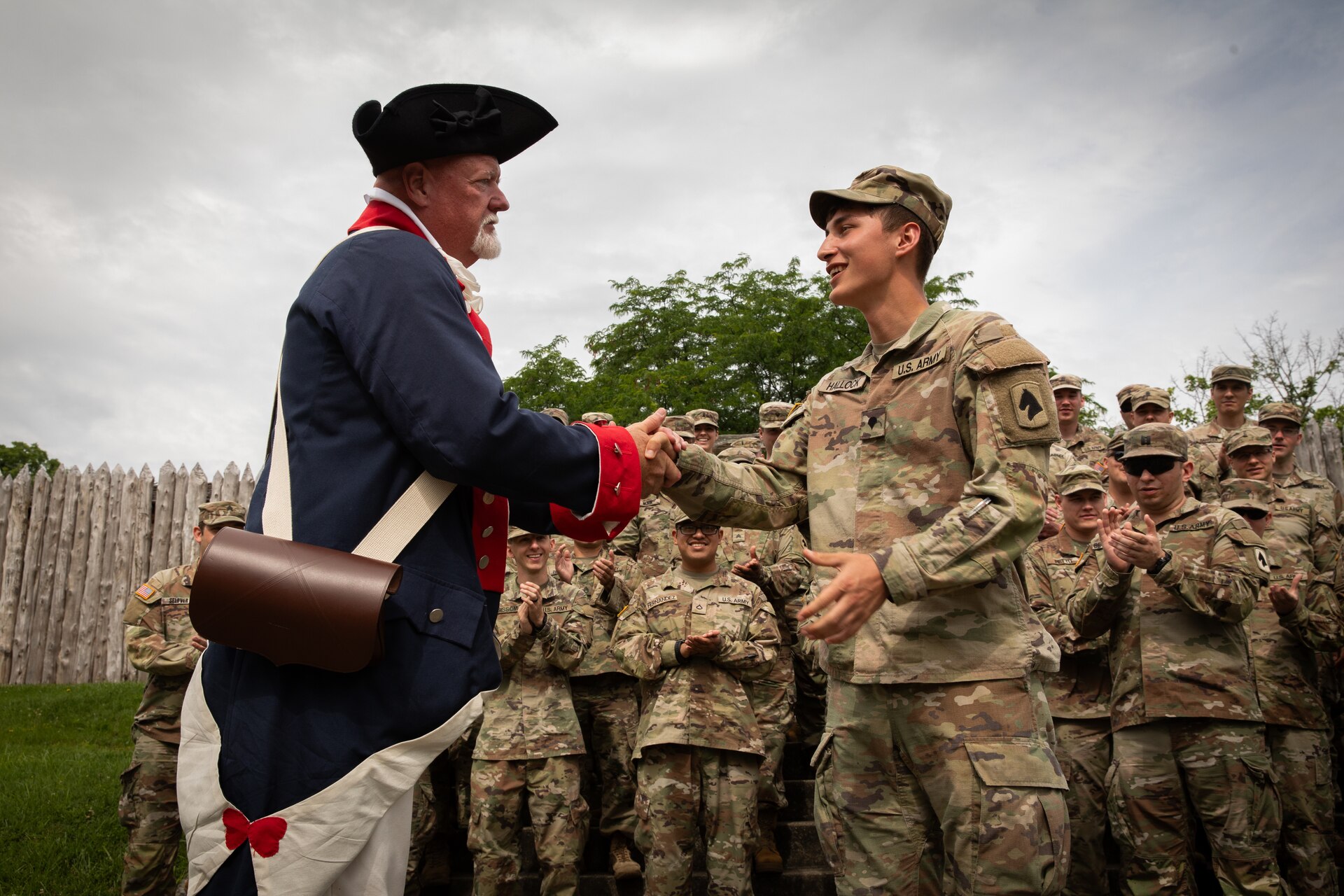 U.S. Army Spc. Caleb Hallock, a chaplain's assistant with the 103rd Brigade Support Battalion, 138th Field Artillery Brigade, receives a cord from Mr. Jim Stinnet, the commander of the Harrodsburg chapter of the Sons of the American Revolution, for being the youngest member of the supporting color guard at Old Fort Harrod State Park in Harrodsburg, Kentucky on June 8, 2024. The 103rd BSB supported the 250th anniversary of the settlement of Harrodsburg by participating in posting the colors, marching in the parade, and providing a static display of military vehicles. (U.S. Army National Guard photo by Sgt. 1st Class Andrew Dickson)