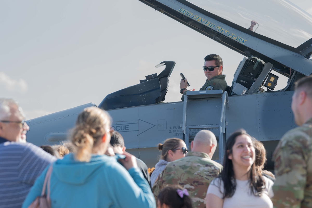U.S. Air Force Maj. Terry Wu, U.S. Air Forces in Europe - Air Forces Africa chief of C-130 Hercules weapons and tactics, observe members of the community after conducting a tour of the aircraft during Ramstein 1v1 at Ramstein Air Base, Germany, June 6, 2024. Ramstein 1v1 is USAFE-AFAFRICA's first-ever basic fighter maneuvers exercise at Ramstein AB, during which military aviators from nine NATO countries engaged in a friendly, tactical exercise to test their rapid decision-making and precise reactions to adversary maneuvers in a high-pressure, demanding setting. (U.S. Air Force photo by Airman 1st Class Trevor Calvert)