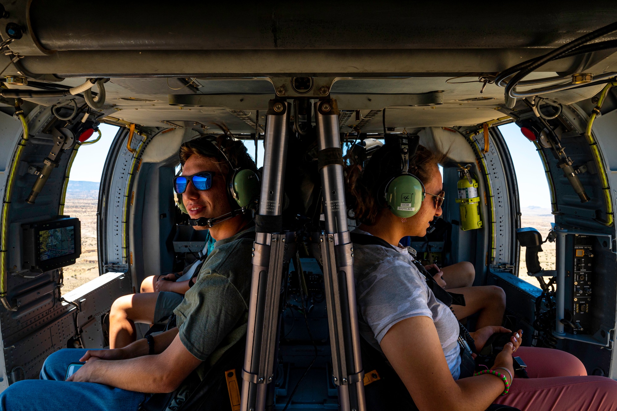 Students look out the window of a helicopter in flight.