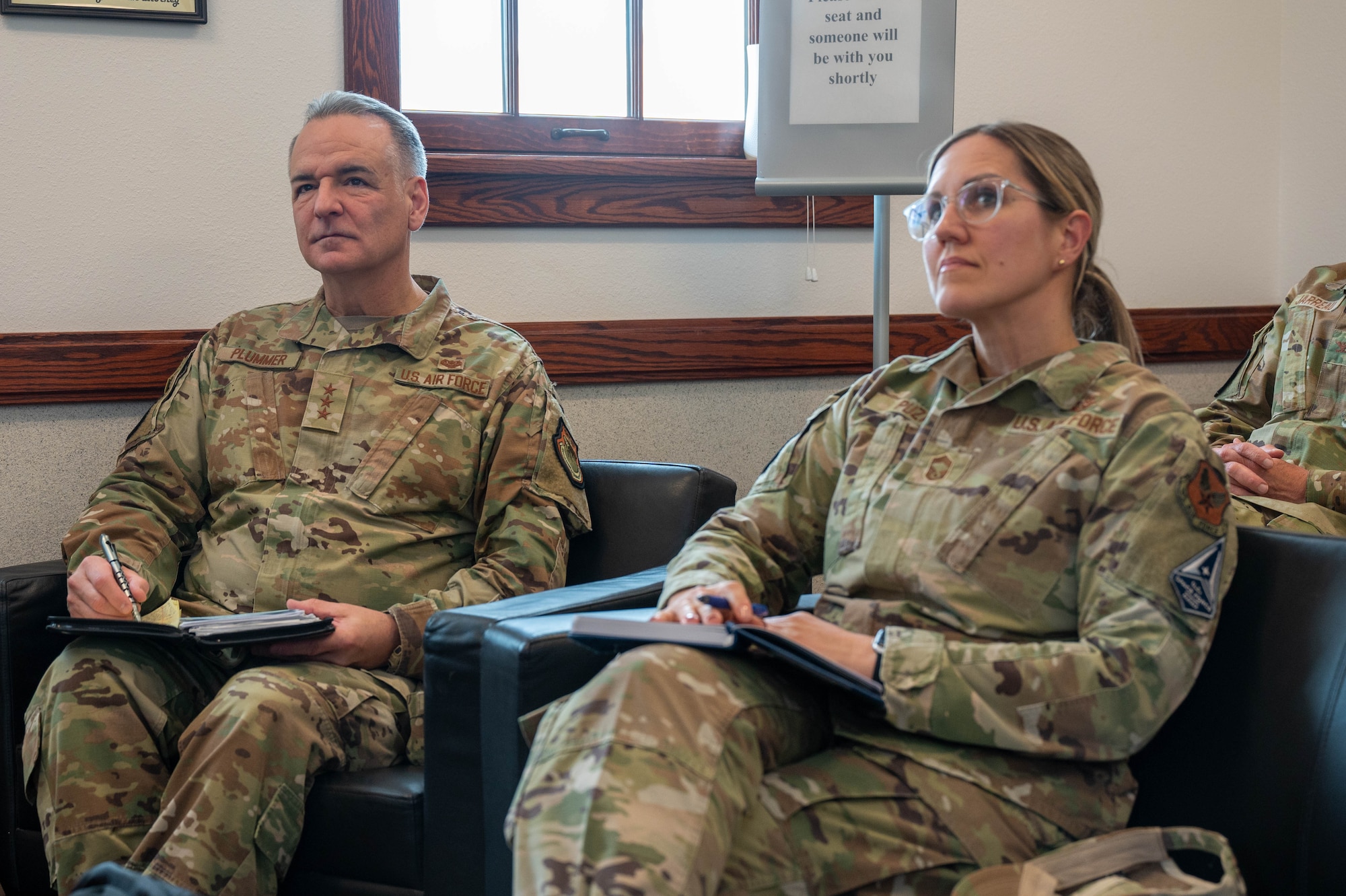 two seated uniformed military members