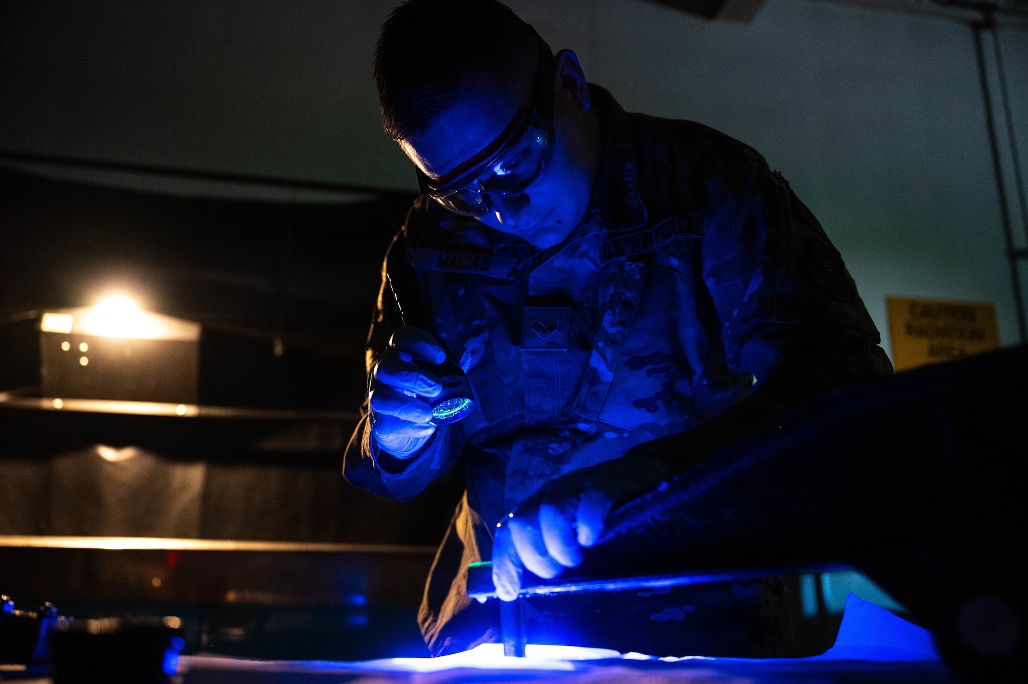 U.S. Air Force Senior Airman Jonathan Macias, 5th Maintenance Squadron non-destructive inspection (NDI) journeyman, inspects a MHU-97/E part during a magnetic particle inspection at Minot Air Force Base, North Dakota, June 6, 2024. NDI technicians use various methods to inspect metal objects to ensure they remain properly functional. (U.S. Air Force photo by Airman 1st Class Luis Gomez)