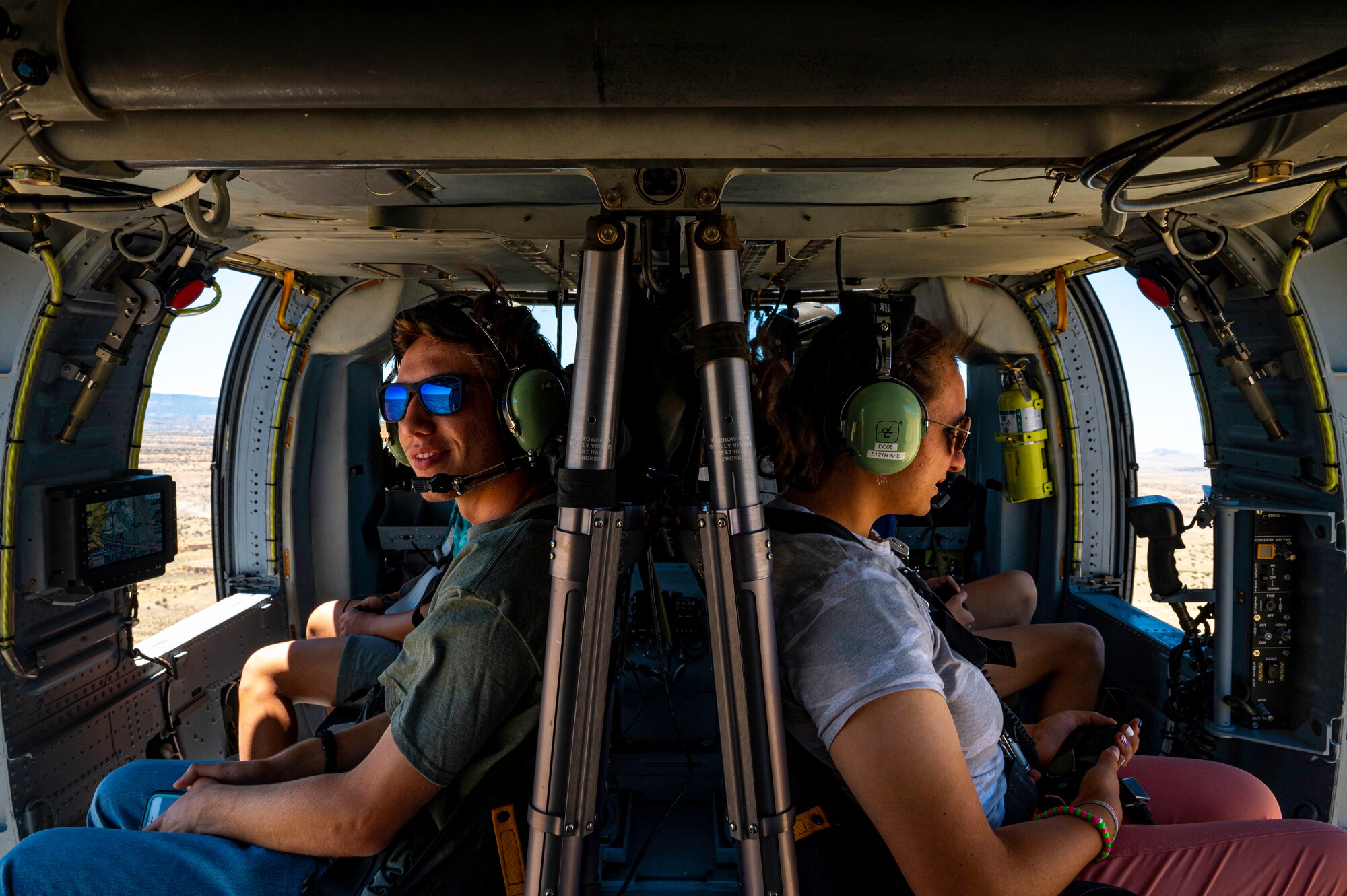 Students look out the window of a helicopter in flight.