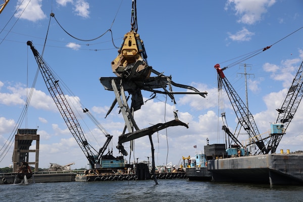 The Chesapeake 1000 (“Chessy”) floating crane equipped with “Gus” the hydraulic grabber, wrestle a 90-ton piece of residual wreckage Friday morning, June 7, 2024, from the Fort McHenry Federal Channel. Taking roughly 45 minutes to unfold, Chessy and Gus slowly lift the mangled steel high above the Patapsco River, so a waiting barge can move underneath, allowing the wreckage to be safely lowered onto the barge for immediate processing by waiting hydraulic sheers.