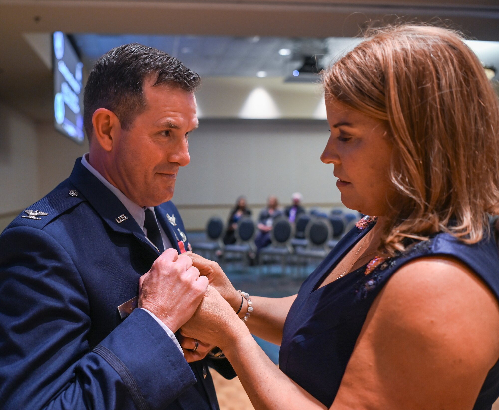 A Space Launch Delta 30 operations vice commander and his wife pins on a retirement pin during the retirement ceremony at Vandenberg Space Force Base.