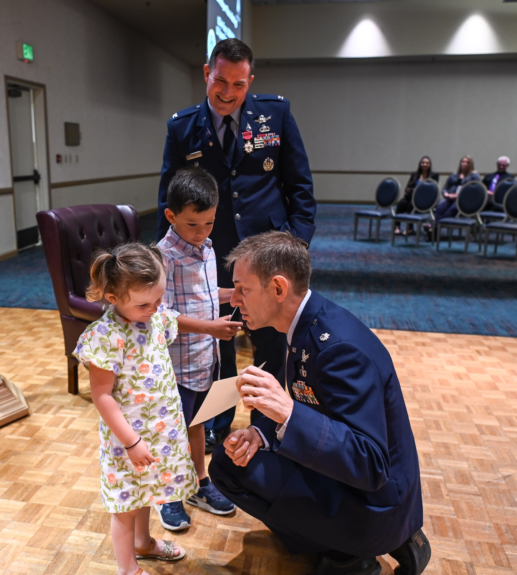 A Space Launch Delta 30 operations vice commander, his children and long time friend look at the certificate of appreciation during the retirement ceremony at Vandenberg Space Force Base.