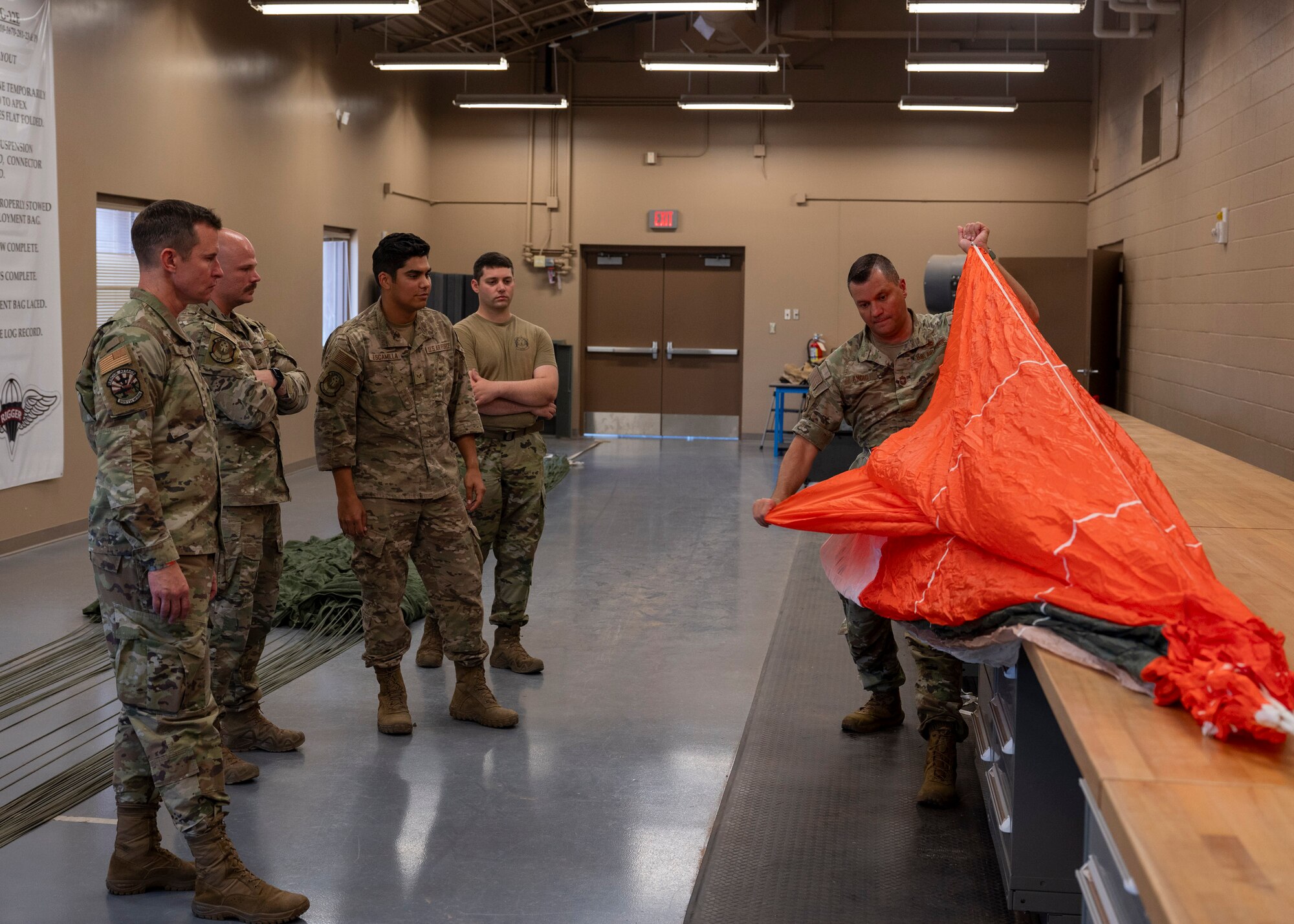 U.S. Air Force Chief Master Sgt. Andre Ancic, 355th Maintenance Group senior enlisted leader, folds a parachute during the Airman for a Day program at Davis-Monthan Air Force Base, Ariz., June  6, 2024. Ancic visited the 563rd Operations Support Squadron to learn about the daily duties they perform. (U.S. Air Force photo by Airman 1st Class William Finn V)