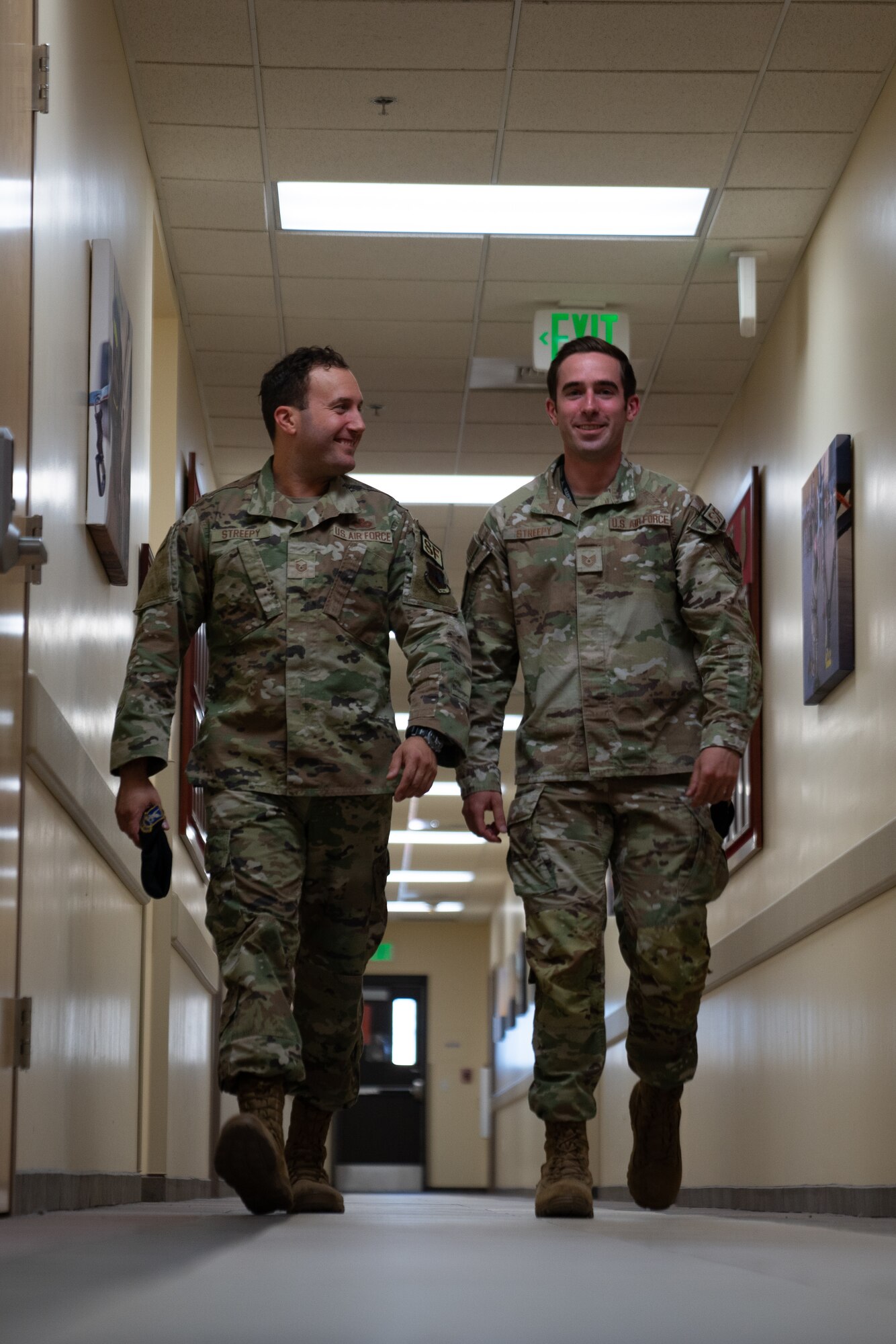 Two men in military uniforms smile for a portrait.