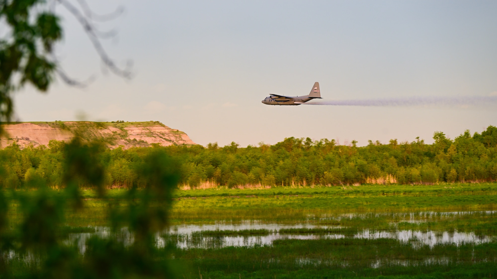 A 910th Airlift Wing aerial spray-modified C-130H Hercules aircraft disperses mosquito control product, June 2, 2024, over the flood banks of the Missouri River south of Williston, North Dakota.
