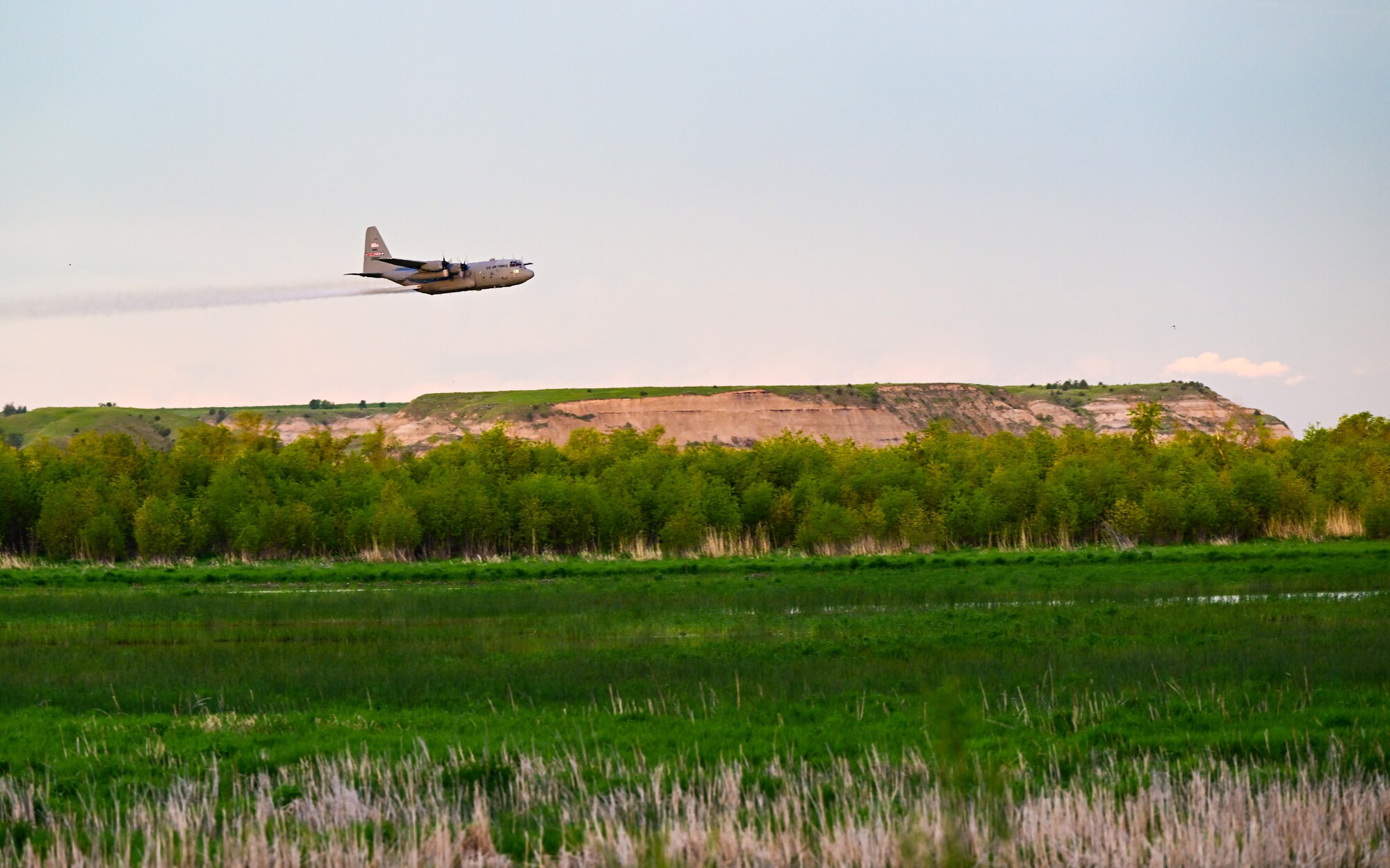 A 910th Airlift Wing aerial spray-modified C-130H Hercules aircraft disperses mosquito control product, June 2, 2024, over the flood banks of the Missouri River south of Williston, North Dakota.