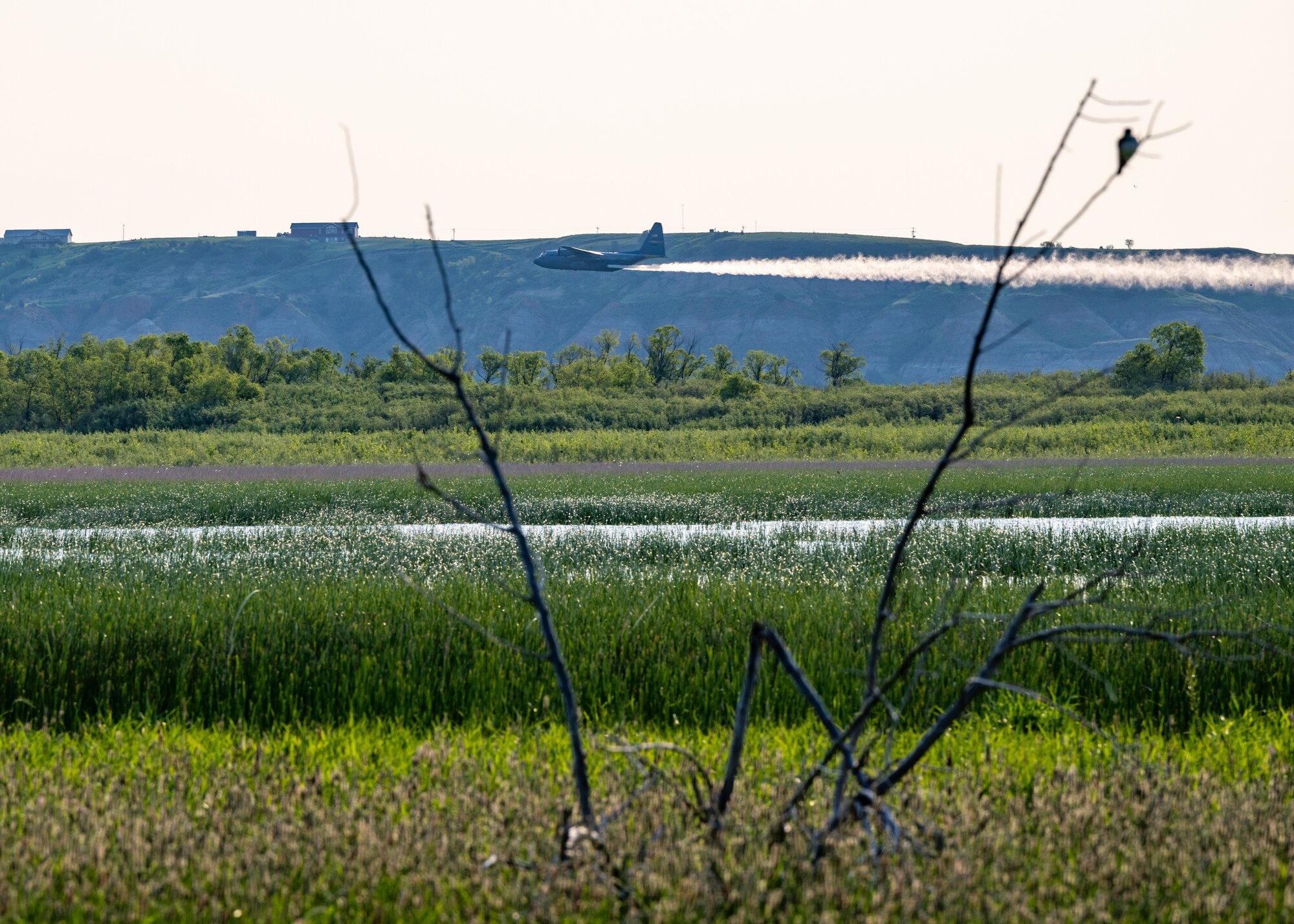 A 910th Airlift Wing aerial spray-modified C-130H Hercules aircraft disperses mosquito control product, May 31, 2024, over the flood banks of the Missouri River south of Williston, North Dakota.