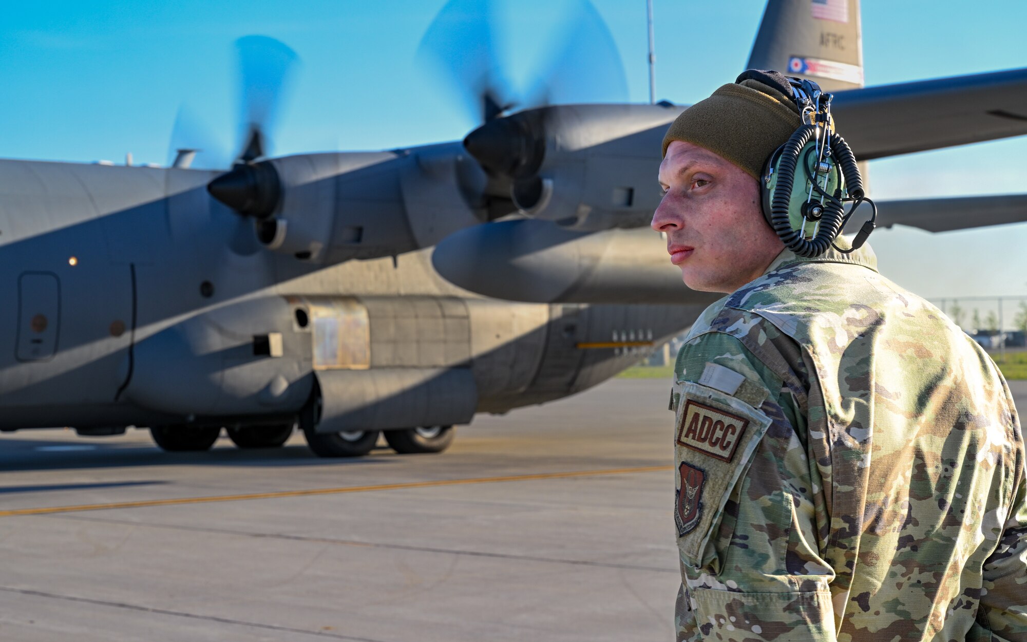 U.S. Air Force Tech. Sgt. Patrick Sherman, a crew chief assigned to the 910th Aircraft Maintenance Squadron, waits to marshal a 910th Airlift Wing aerial spray-modified C-130H Hercules aircraft preparing to takeoff, May 29, 2024, from Williston Basin International Airport, North Dakota.