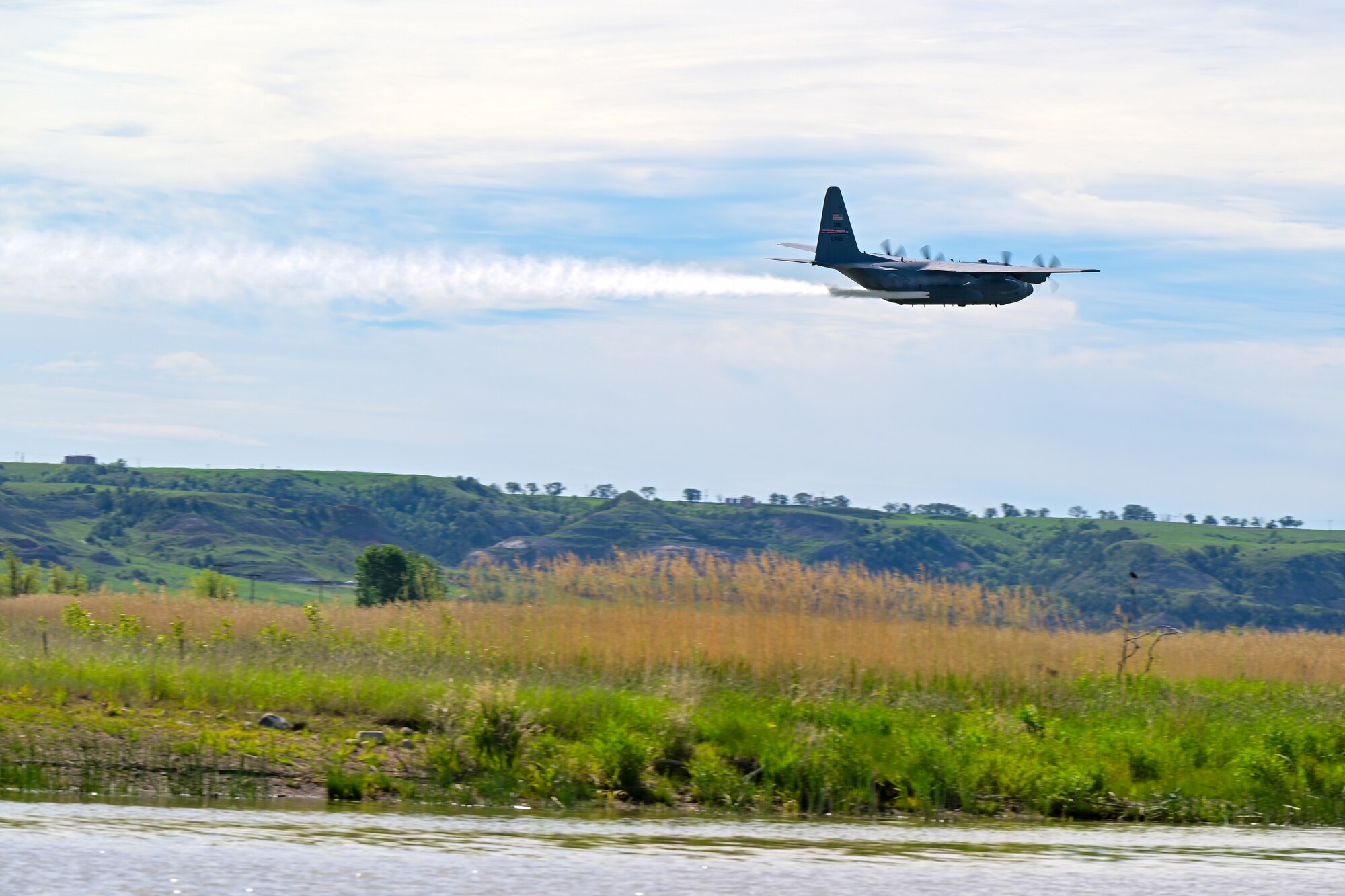 A 910th Airlift Wing aerial spray-modified C-130H Hercules aircraft disperses mosquito control product, June 3, 2024, over the flood banks of the Missouri River south of Williston, North Dakota.