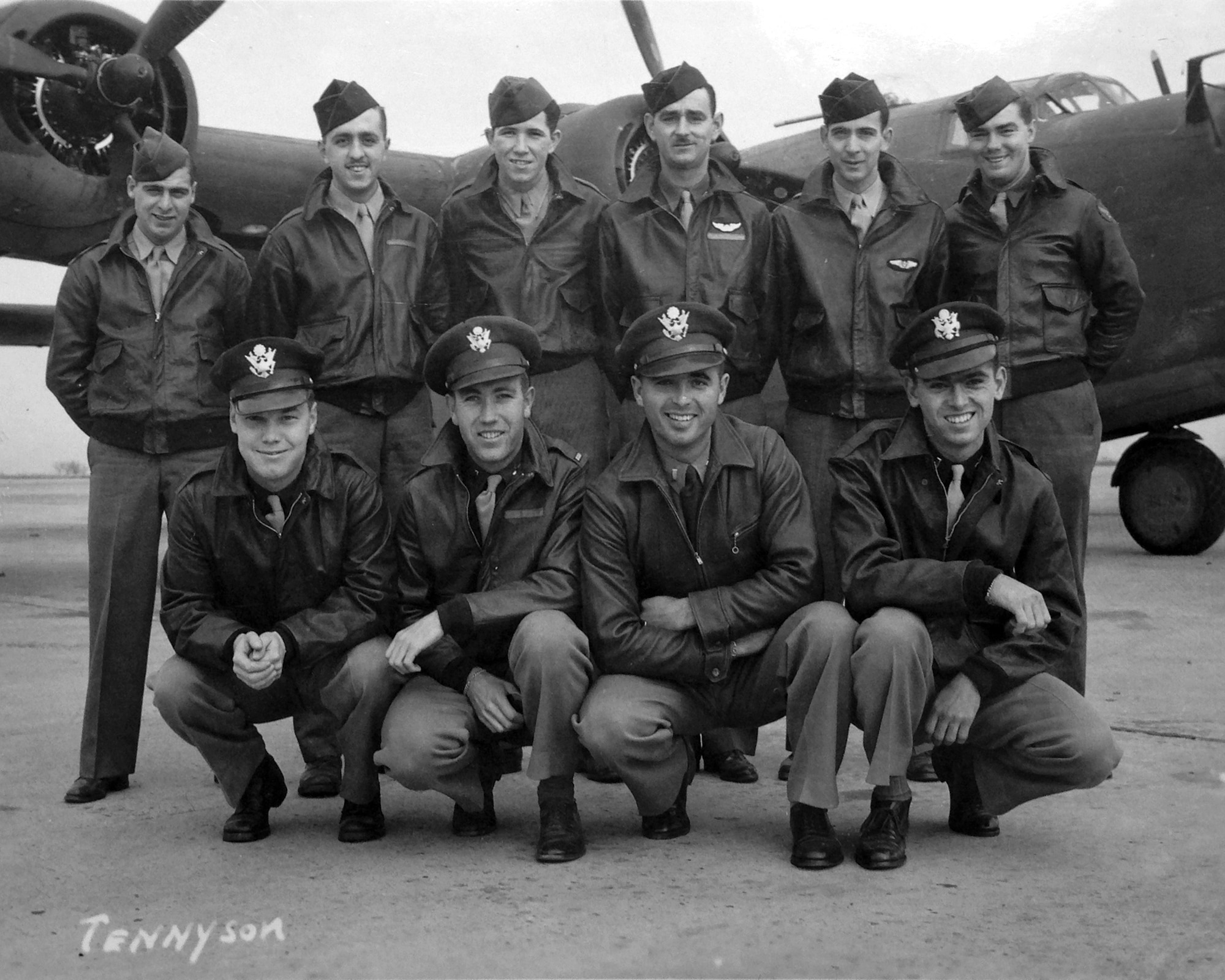 black and white posed photo of ten Army Air Forces personnel in uniform in front of their aircraft
