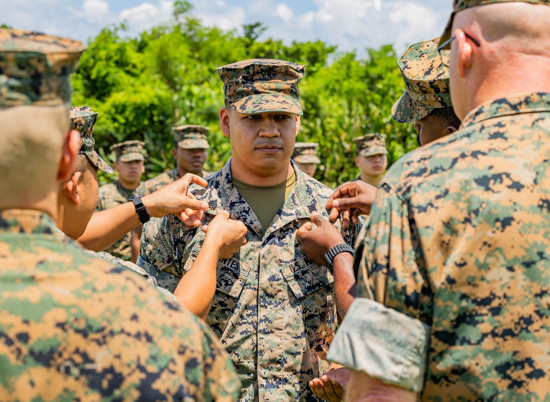 Sgt. Rogelio Cervantes, an administrative clerk with the 3rd Marine Expeditionary Brigade and a native of California, gets pinned to the rank of sergeant by those who positively impacted him during his promotion ceremony at Camp Courtney, Okinawa, June 5, 2024.