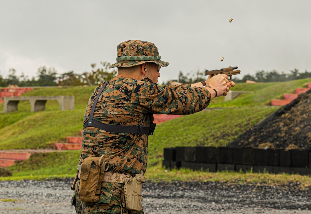 Sgt. Matthew Sampson, a fires support system operator with 3d MEB, fires an M18 service pistol during an intramural pistol competition at Camp Hansen Pistol Range, Okinawa, Japan, May 24, 2024.