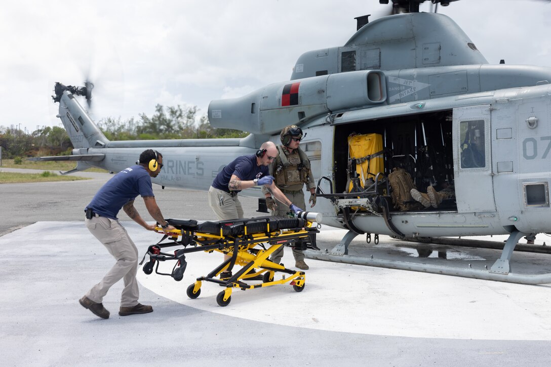 U.S. Navy personnel move a gurney during a simulated casualty evacuation operation with Marine Light Attack Helicopter Squadron (HMLA) 167, at the U.S. Navy Atlantic Undersea Test and Evaluation Center, on Andros Island, Bahamas, June 5, 2024. HMLA-167 conducted simulated casualty evacuation operations in support of Distributed Aviation Operations Exercise 24, which is designed to distribute command and control of aviation forces across echelons of command, pushing authorities to the lowest levels, while keeping forces moving between airfields and air sites. (U.S. Marine Corps photo by Lance Cpl. Anakin Smith)
