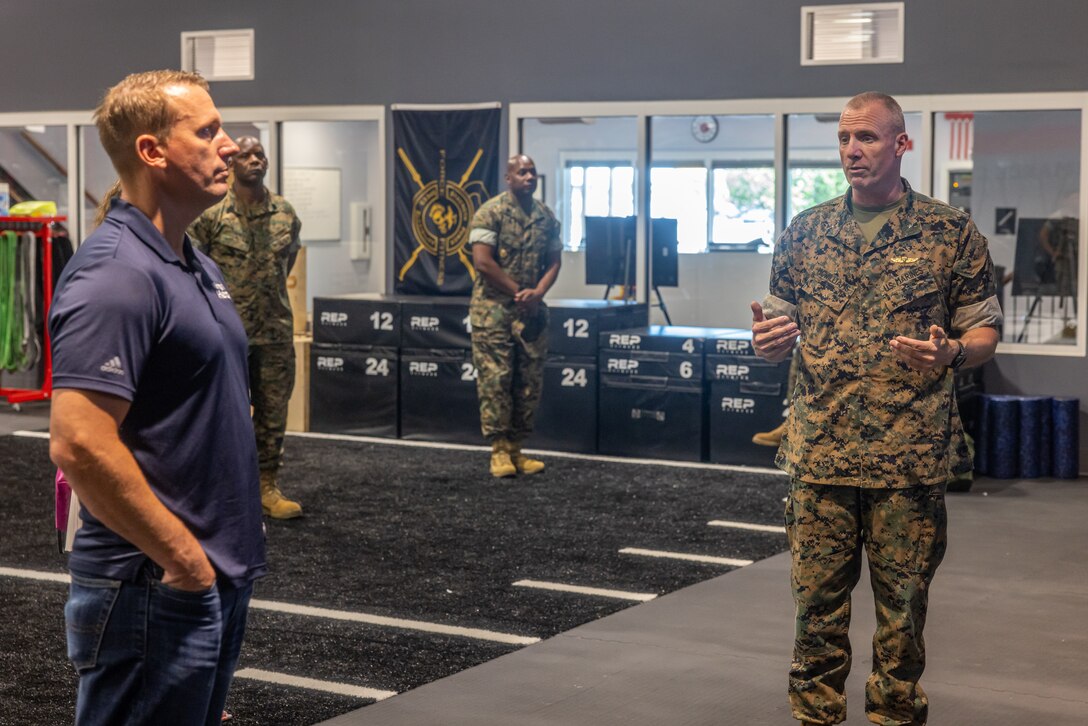 Dakota Meyer, left, Medal of Honor recipient, speaks with U.S. Marine Corps Brig. Gen. Michael E. McWilliams, commanding general, 2nd Marine Logistics Group, about the capabilities of the Human Performance Center on Camp Lejeune, North Carolina, June 3, 2024. Dakota Meyer is one of three Marine Corps Medal of Honor recipients during the Global War on Terror. Meyer spoke with 2nd MLG's leadership discussing the overall benefits of the Human Performance Center and how it could be used as a tool to assist Marines in improving in all areas of mind, body, and spirit. (U.S. Marine Corps photo by Lance Cpl. Christian Salazar)