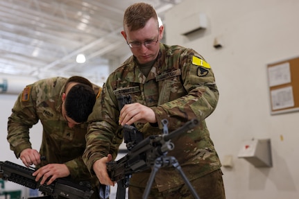 Sgt. Jason R. Paglia and Sgt. Charles C. Roberts, biomedical equipment specialists with the U.S. Army Medical Materiel Agency’s Medical Maintenance Operations Division (MMOD-UT), practice assembling the M249 Squad Automatic Weapon during the Best Warrior Competition on Aberdeen Proving Ground, Maryland, May 8. Paglia and Roberts, who are both stationed at Hill Air Force Base, Utah, also competed for the best time in assembling and disassembling the M17 Pistol and the M4 Carbine Assault Rifle. (U.S. Army photo by Marshall R. Mason)