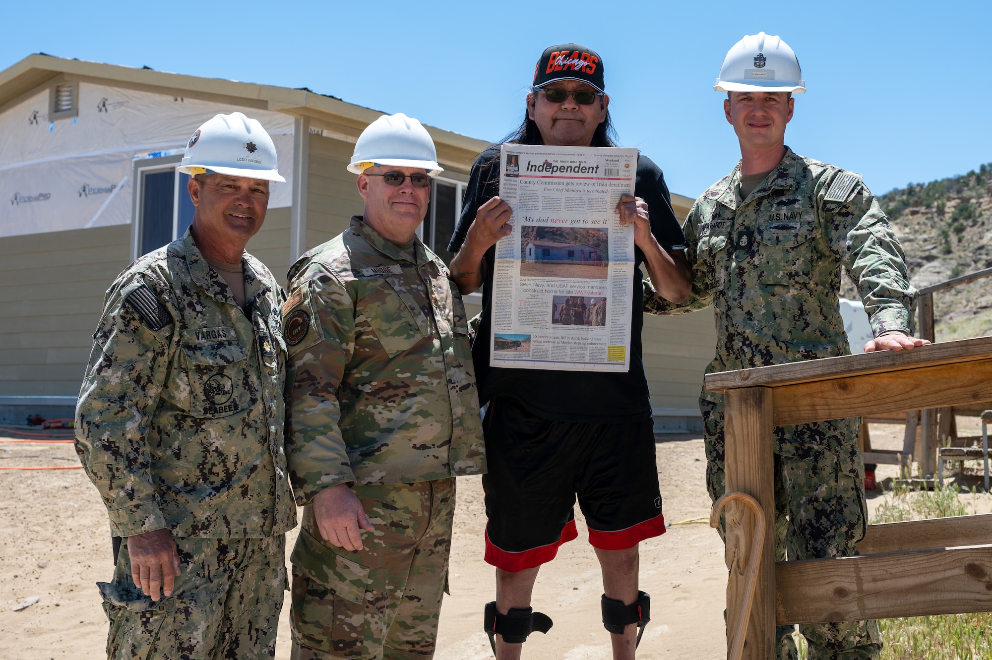 Service members and tribe member pose for photo.
