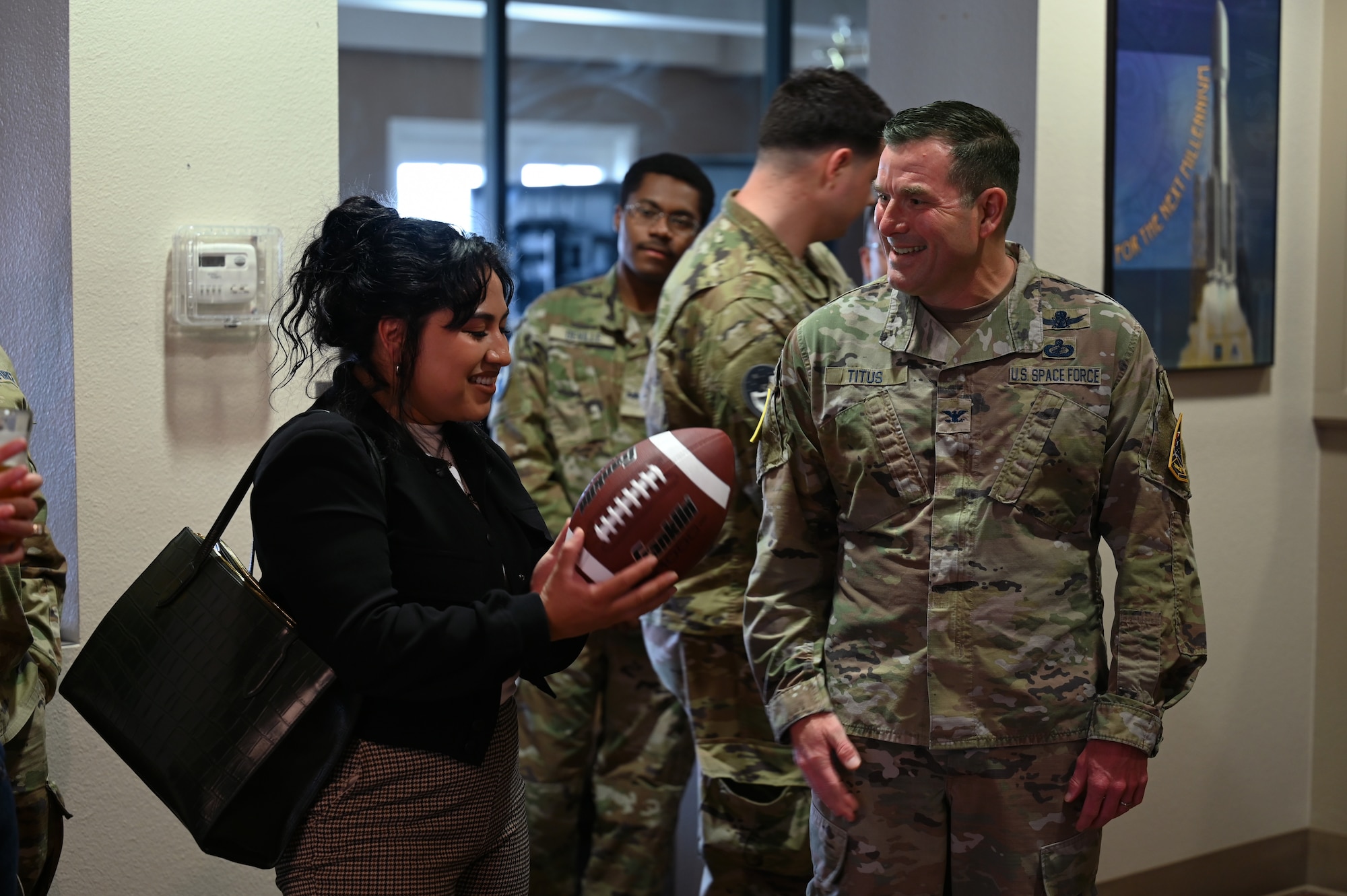 A man gives a woman a football.