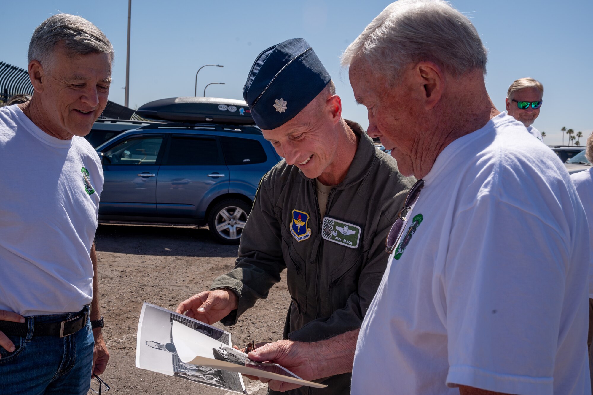Retired U.S. Air Force Lt. Col. David Kling (right) shows Lt. Col. Brett Black (center), 308th Fighter Squadron commander, photos from his time with the 308th FS during a heritage tour, March. 31, 2024 at Luke Air Force Base, Arizona.