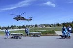 Medical staff from Aurora Medical Center-Summit’s emergency and trauma center wait for a Wisconsin Army National Guard Black Hawk helicopter to arrive so they can move notional patients to the emergency room during a mass casualty exercise May 31. The scenario called for a single Black Hawk crew to medically evacuate three victims critically injured by a building collapse. A Black Hawk can transport up to four litter-borne patients, as opposed to civilian air ambulances which carry only one patient. One of the mock patients would later be transferred by Black Hawk to Aurora Bay Care Medical Center in Green Bay. This training builds on prior collaboration between the Wisconsin Army National Guard and Aurora Health Care. Wisconsin Department of Military Affairs photo by Vaughn R. Larson