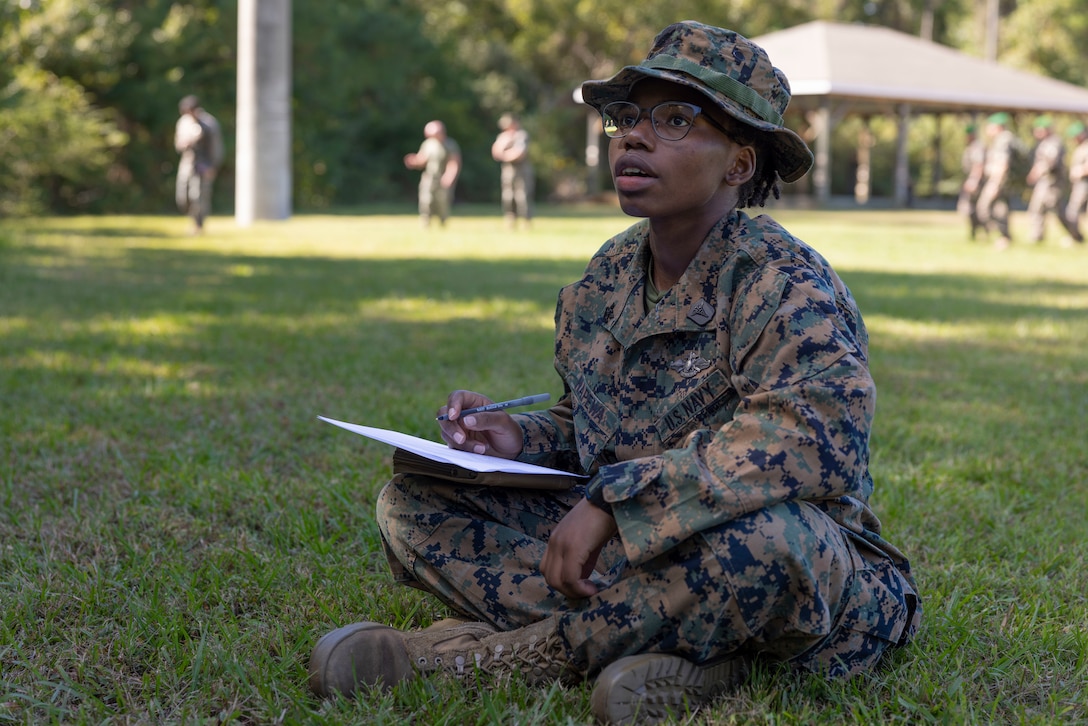U.S. Navy Petty Officer 2nd Class Janette Napewa, a Caledonia, Michigan native and a hospital corpsman with Bravo Company, 2nd Light Armored Reconnaissance (LAR) Battalion, 2nd Marine Division, asks a question about the written exam during the Scout School screener on Camp Lejeune, North Carolina, October 16, 2023. The 2nd LAR Scout School includes instruction in marksmanship, field skills, communications, land navigation, patrolling and combat conditioning. (U.S. Marine Corps photo by Lance Cpl. Cara Castañeda)