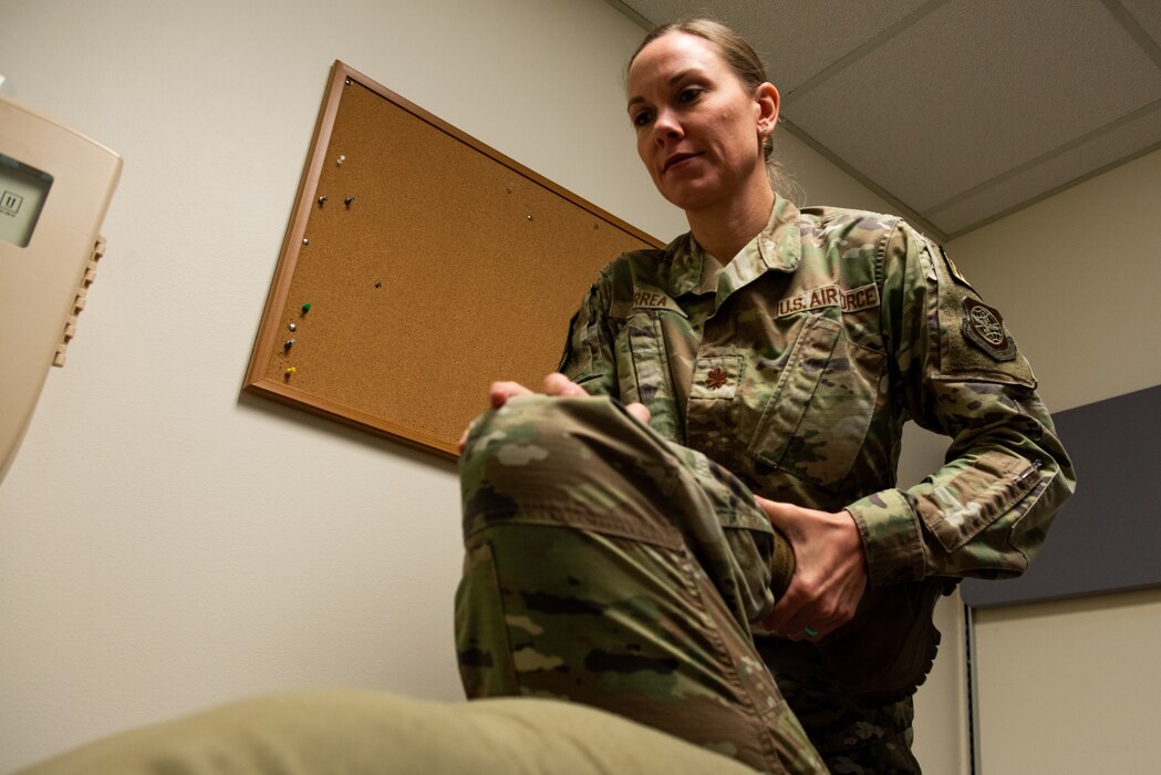 Airman performs physical therapy on patient