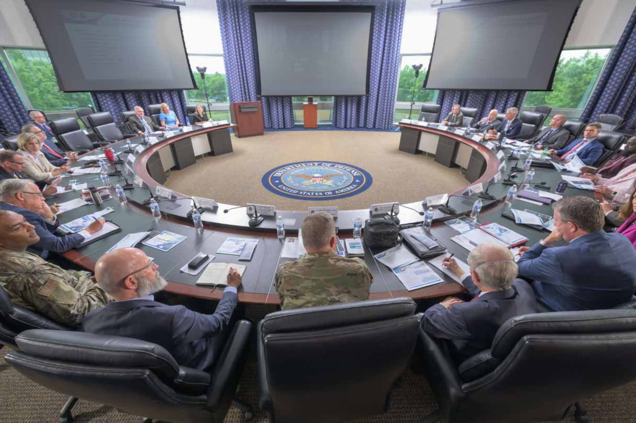 Men and women sit around a large, circular table.