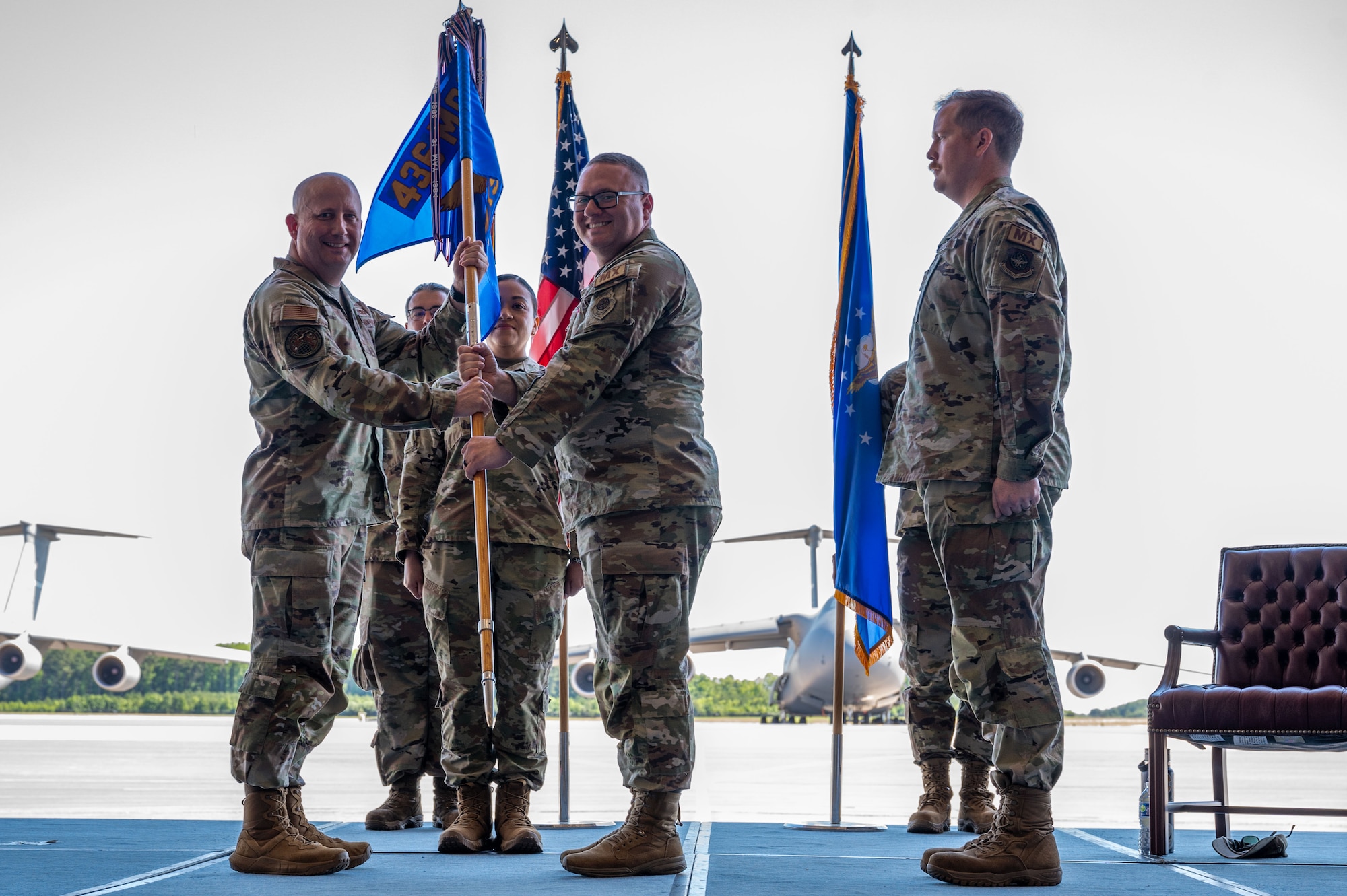 U.S. Air Force Lt. Col. Alexander Barnett, right, outgoing 436th Maintenance Squadron commander, passes the guidon to Col. Bary Flack, 436th Mission Generation Group commander, during a change of command ceremony at Dover Air Force Base, Delaware, June 10, 2024. The ceremony saw Barnett relinquish command to Maj. Joshua Belanger. (U.S. Air Force photo by Senior Airman Amanda Jett)