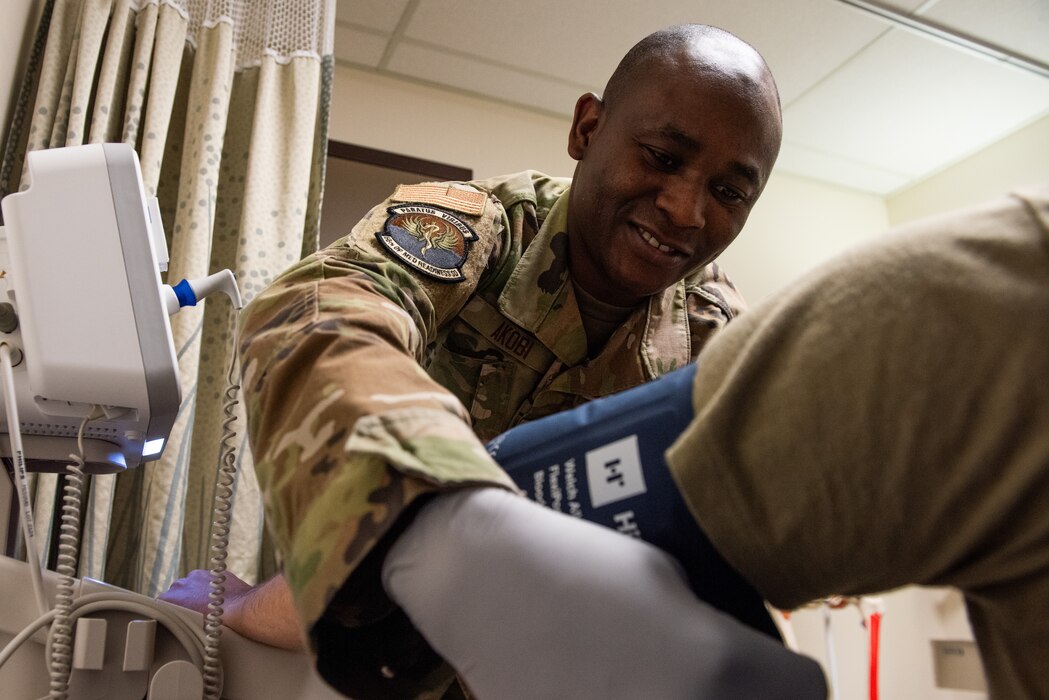 Airman applies blood pressure cuff to patient