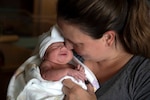 A mother and her newborn daughter snuggle following an evaluation of the infant at the U.S. Naval Hospital in Okinawa, Japan, July 18, 2023.