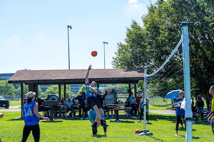 military and civilian personnel playing a game of volleyball