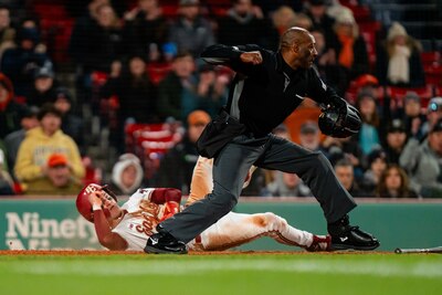 Linus Baker playing umpire during baseball game.