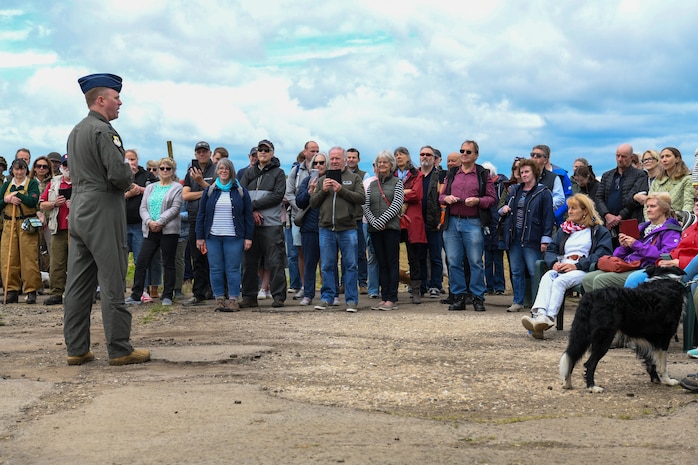 U.S. Air Force Lt. Col. Brad Fisher, commander of the 15th Airlift Squadron, delivers remarks to a gathered crowd during the ceremony at the RAF Ramsbury Community Fair, honoring the 80th anniversary of D-Day, June 8, 2024, in Ramsbury, U.K. Members of the local community and visitors listened attentively as Fisher recounted the courageous efforts of the 437th Troop Carrier Group, detailing their critical role in the airborne operations of D-Day and their significant contributions throughout World War II. (U.S. Air Force photo by 1st Lt. Taylor Ferry)