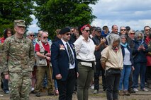 U.S. Air Force Maj. David Martin, commander of the 437th Aerial Port Squadron, stands at attention with event organizers during a moment of silence at the RAF Ramsbury Community Fair, June 8, 2024, in Ramsbury, U.K. The ceremony marked the 80th anniversary of D-Day, honoring the sacrifices and contributions of those who served. (U.S. Air Force photo by 1st Lt. Taylor Ferry)