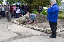 U.S. Air Force Maj. David Martin, commander of the 437th Aerial Port Squadron, lays a wreath at the memorial dedicated to the 437th Troop Carrier Group during the RAF Ramsbury Community Fair, June 8, 2024, in Ramsbury, U.K. The ceremony, which included a bugler playing "The Last Post," was part of the events commemorating the 80th anniversary of D-Day, honoring the sacrifices and contributions of those who served. (U.S. Air Force photo by 1st Lt. Taylor Ferry)