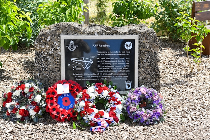 The memorial dedicated to the 437th Troop Carrier Group at RAF Ramsbury, adorned with wreaths laid during the RAF Ramsbury Community Fair, June 8, 2024, in Ramsbury, U.K. The memorial honors the units based at RAF Ramsbury from 1942 to 1946 and their significant contributions during D-Day and throughout World War II. (U.S. Air Force photo by 1st Lt. Taylor Ferry)