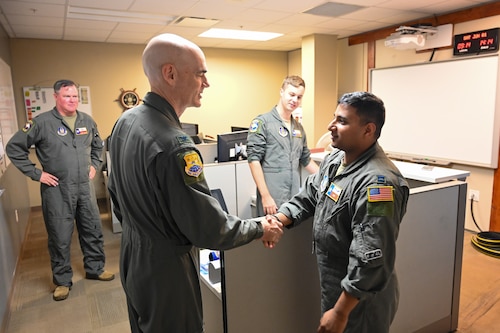 Col. William Gutermuth, 433rd Airlift Wing commander, presents his wing commander’s coin to Capt. Michael Fast, 68th Airlift Squadron tactician and C-5 pilot, for his intervention during a vehicle accident.