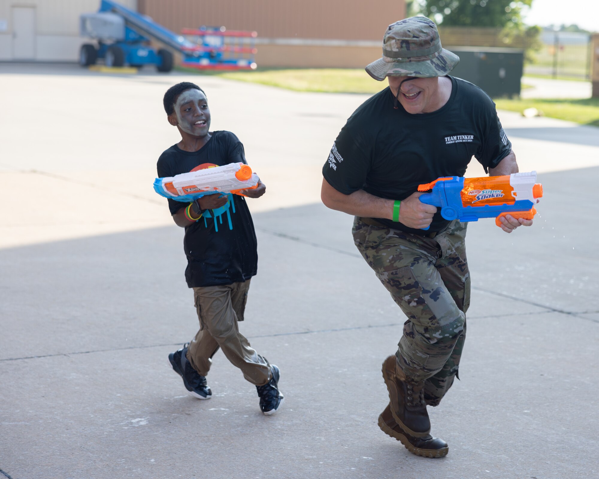 Man and boy playing with water gun