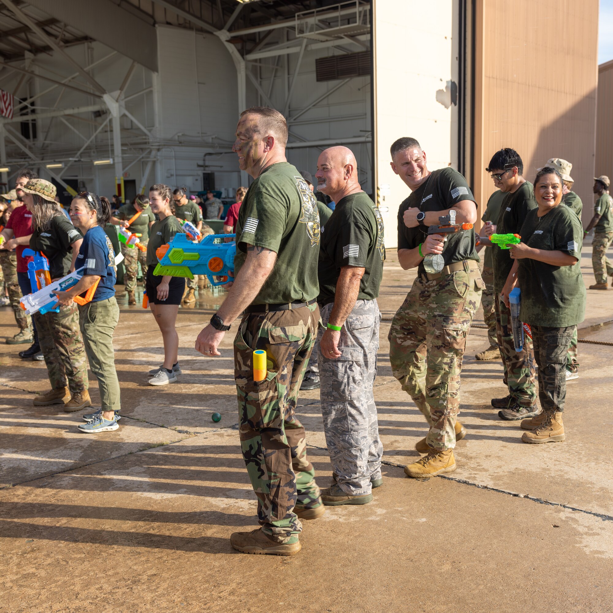 Men and women shooting water guns